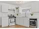 Modern white kitchen with stainless steel appliances and herringbone backsplash at 5111 Orinda Ave, Las Vegas, NV 89120