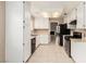 Kitchen boasts white cabinets, stainless steel appliances, and tile floors at 7556 Kalmalii Ave, Las Vegas, NV 89147