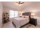 Spacious bedroom with a tufted headboard and wood nightstands at 8516 Spyrun Dr, Las Vegas, NV 89134