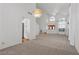 Open dining area adjacent to the living room, featuring high ceilings and carpeted floors at 8636 Grandbank Dr, Las Vegas, NV 89145