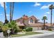 Two-story home with tile roof, three-car garage, and palm trees at 8636 Grandbank Dr, Las Vegas, NV 89145