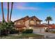 Two-story home with tile roof, three-car garage, and palm trees at 8636 Grandbank Dr, Las Vegas, NV 89145