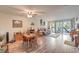 Living room with sliding glass doors, wood-look floors, and adjacent dining area at 2465 El Paseo Cir, Las Vegas, NV 89121