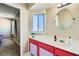 Simple bathroom with red vanity and a round mirror at 4224 Timpani Dr, Las Vegas, NV 89110