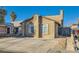 Tan two-story house with a paved driveway and mature trees at 4224 Timpani Dr, Las Vegas, NV 89110