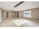 Living room with ample natural light, wood-look flooring, and access to another room at 6436 Tanager Way, Las Vegas, NV 89103