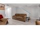 Living room with a brown couch, a staircase, light gray walls, and wood-look flooring at 7078 Burcot Ave # B15, Las Vegas, NV 89156