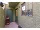 Back patio with a green door and a hand truck near an ADT security sign at 7078 Burcot Ave # B15, Las Vegas, NV 89156