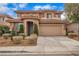 Two-story house with neutral exterior, landscaping, and a two-car garage at 11045 Village Ridge Ln, Las Vegas, NV 89135