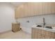 Bright laundry room with modern cabinetry and a utility sink at 19 Rue Grimaldi Way, Henderson, NV 89011