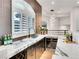 Sophisticated wet bar with a marble countertop, wine fridge, and window views at 211 Granite Ct, Boulder City, NV 89005