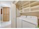 Well-lit laundry room with washer, dryer, and ample shelving at 2701 Rising Legend Way, Las Vegas, NV 89106