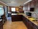 Kitchen with dark wood cabinets, granite counters, and island at 3660 Timberlake Dr, Las Vegas, NV 89115