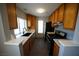 Modern kitchen with wood cabinets, granite countertops, black appliances, and a window at 4878 Nara Vista Way # 203, Las Vegas, NV 89103