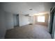 Spacious living room with carpeted flooring and a window, showing a hallway entrance at 4878 Nara Vista Way # 203, Las Vegas, NV 89103