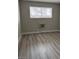 Empty bedroom with wood-look vinyl flooring and window air conditioner at 5436 Swenson St # 16, Las Vegas, NV 89119