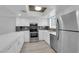 Updated kitchen featuring white cabinets, stainless steel appliances, and gray backsplash at 6263 W Washington Ave, Las Vegas, NV 89107