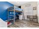 bedroom featuring a loft bed with built-in desk and blue accent wall at 7141 Royal Melbourne Dr, Las Vegas, NV 89131