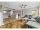 Open living room with wood floors, gray sectional sofa, and view of the kitchen at 7141 Royal Melbourne Dr, Las Vegas, NV 89131