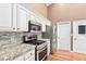 Kitchen with granite countertops, stainless steel appliances, and white cabinets at 1053 Plentywood Pl, Henderson, NV 89002