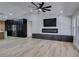 View of the living room with a marble fireplace, large TV, and wood-look flooring at 160 Swale Ln, Las Vegas, NV 89144