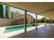 Relaxing pool with a covered patio and lush green lawn in the backyard at 160 Swale Ln, Las Vegas, NV 89144