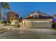 Two-story house with a three-car garage and landscaped front yard at dusk at 2848 Cape Verde Ln, Las Vegas, NV 89128