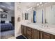 Double vanity bathroom with white countertop, brown cabinets, and large mirror at 4729 Dream Catcher Ave, Las Vegas, NV 89129