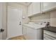 Laundry room with white cabinets, washer, dryer, and black countertop at 9514 Teton Vista Ave, Las Vegas, NV 89117