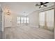 Bright living room with vaulted ceiling, wood-look flooring, and large windows at 9514 Teton Vista Ave, Las Vegas, NV 89117