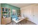 Home office with green accent wall, desk, and shelving unit at 1409 Covert Cove Pl # 120, North Las Vegas, NV 89084