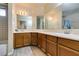 Dual sink bathroom with wooden vanity, large mirror, and modern fixtures at 1464 Briggs Ct, Las Vegas, NV 89110