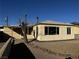 Tan single story home with a covered patio and small front yard at 148 W Victory Rd, Henderson, NV 89015