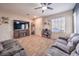 Living room with comfortable seating, a large TV, and wood-look tile floors at 277 Melody Vista Ln, Henderson, NV 89015