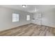 Bright living room with wood-look flooring, white walls, and a small kitchen area at 4125 Monja Ct, Las Vegas, NV 89104