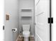 Small, modern bathroom with a toilet, white shelves, and gray walls at 5456 Digne Ct, Las Vegas, NV 89141