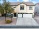 Front view of a two-story house with a two-car garage, landscaped yard, and a tree at 5456 Digne Ct, Las Vegas, NV 89141