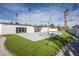 Expansive backyard with a pool, artificial turf, and a modern white house at 5600 Topaz St, Las Vegas, NV 89120