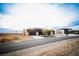 Street view of a contemporary home in a desert community with a two-car garage and minimalist landscaping at 6059 E Spring Mountain Blvd, Pahrump, NV 89048