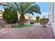 Landscaped backyard with a palm tree, artificial turf, and a fire pit at 6278 Bold Regatta Ct, Las Vegas, NV 89139