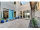 Inviting courtyard with a bright blue door, potted plants, and large windows at 6800 Equinox Cliff St, Las Vegas, NV 89135