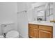 Half bathroom with single vanity, mirror, and oak cabinet at 711 Peregrine Falcon St, Henderson, NV 89015