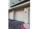 Condo garage with white roll-up door and red curb at 7139 S Durango Dr # 218, Las Vegas, NV 89113