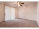 Empty bedroom with carpeted floors, ceiling fan, and vertical blinds at 7163 S Durango Dr # 113, Las Vegas, NV 89113