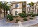 Exterior view of a two-story condo building with desert landscaping and palm trees at 7163 S Durango Dr # 113, Las Vegas, NV 89113