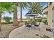 Spacious patio with seating area, umbrella, and lush landscaping at 8390 Carmel Ridge Ct, Las Vegas, NV 89113