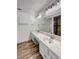 Modern bathroom featuring dual vanities, wood-style flooring, and a sleek mirror at 1240 Linn Ln, Las Vegas, NV 89110