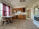 Kitchen with wooden cabinets, a tiled floor, a dining table, and a window at 26 Avenue E, McGill, NV 89318