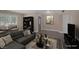 Virtually staged living room with gray sectional sofa and wood-look floors at 401 Altamira Rd, Las Vegas, NV 89145