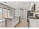 Bright kitchen featuring white cabinets, center island, and sliding door to patio at 542 Celebratory Pl, Henderson, NV 89011